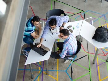 A team of network technicians carefully planning a network installation project in a business setting.
